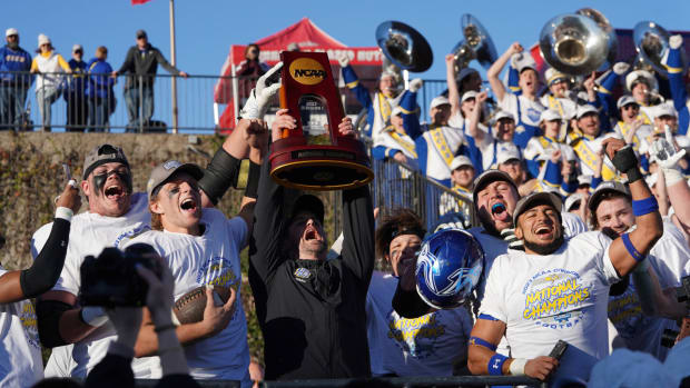 South Dakota State coach Jimmy Rogers hoists the FCS national championship trophy.